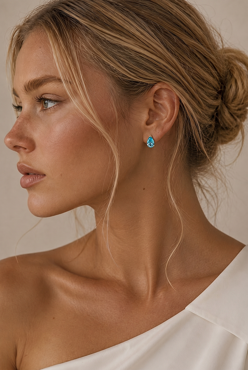 Woman wearing turquoise earrings with a neutral background